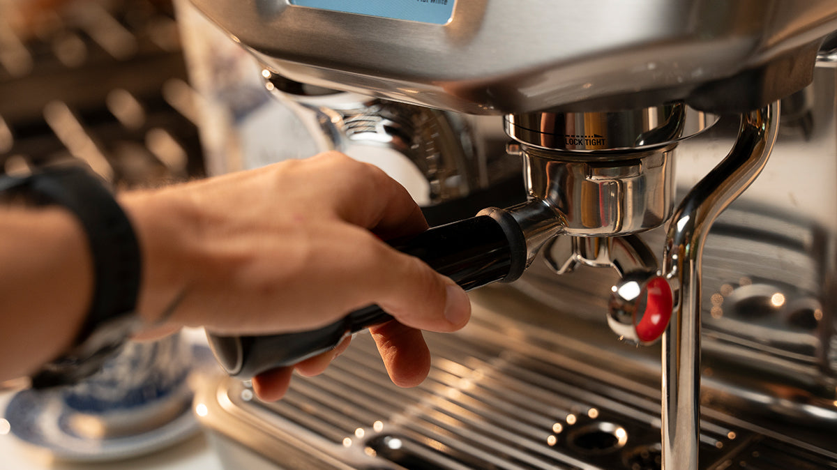 hand securing portafilter in espresso machine